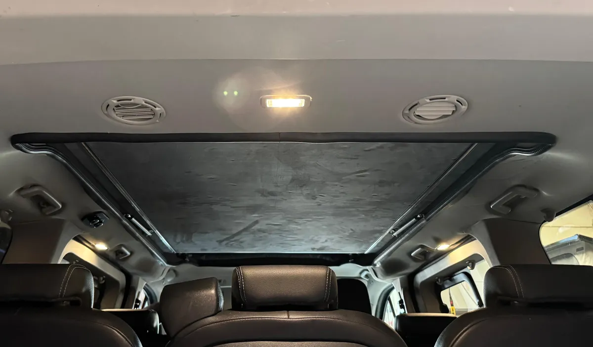 Blick nach hinten im Ford Tourneo Custom: geschlossenes Aufstelldach mit Alcantara, daneben Lüftungsdüsen und Leuchte der Klimaanlage