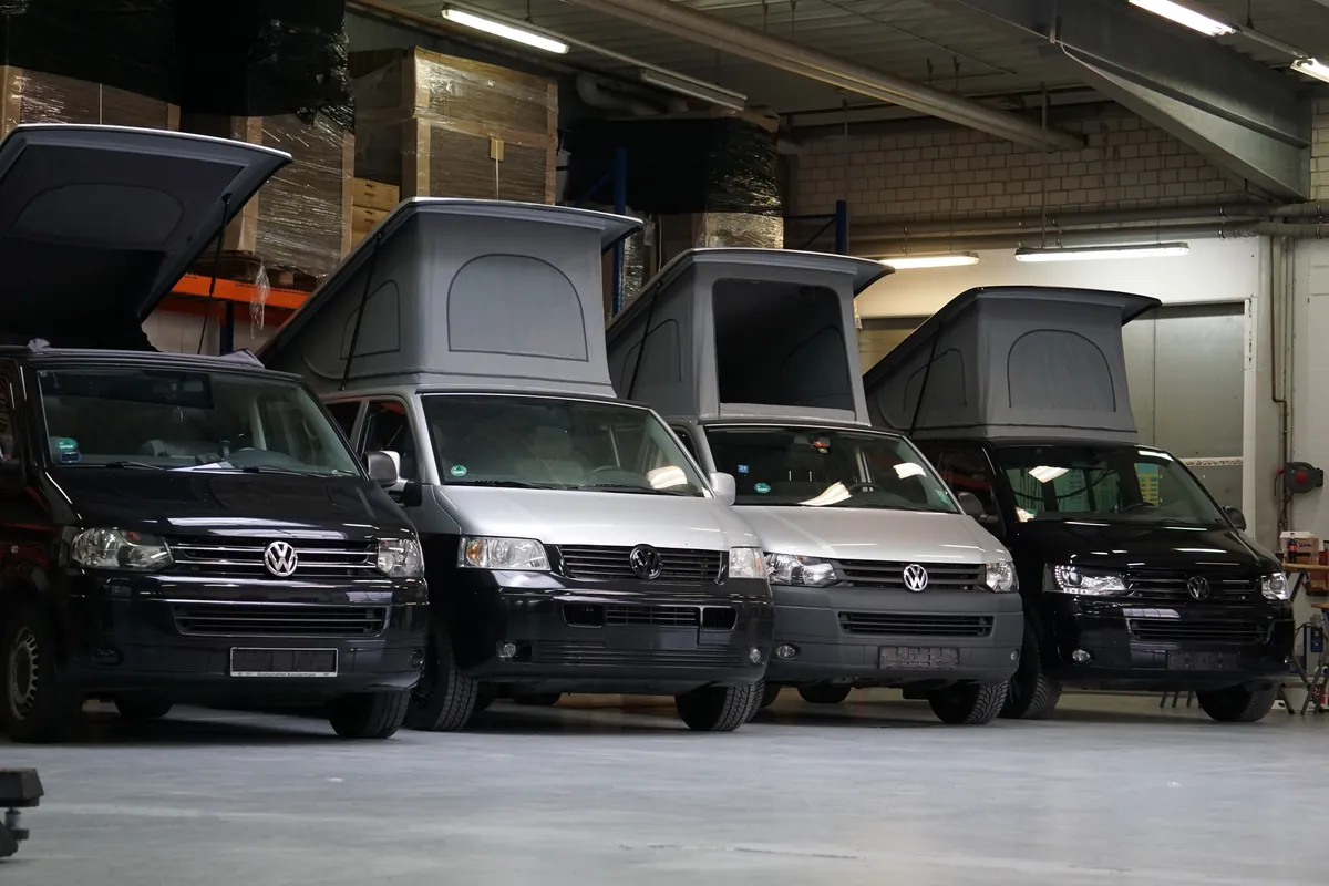 Vier VW Busse mit geöffnetem Aufstelldach nebeneinander in unserer Halle