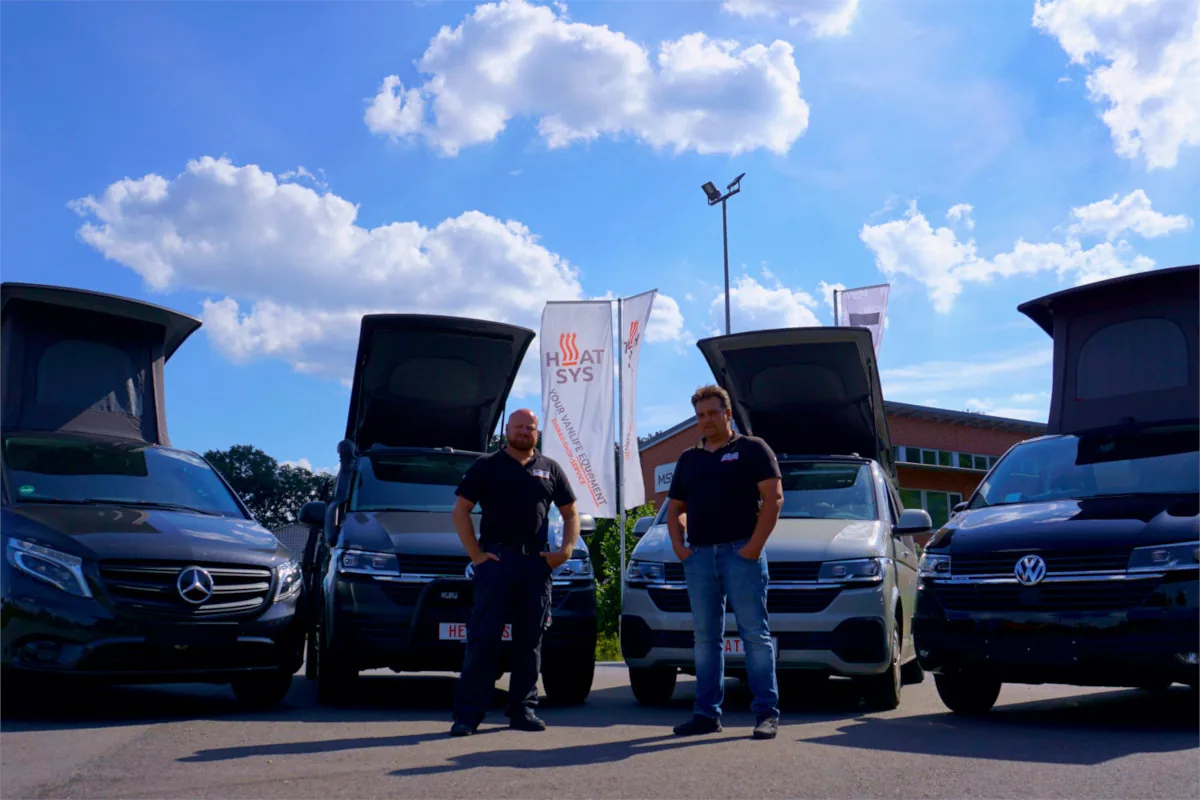 Andrej (links) und Waldemar vor umgebauten Vans mit Aufstelldach