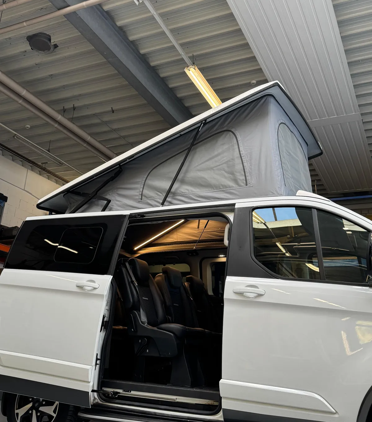 Ford Tourneo Custom mit geöffnetem Aufstelldach und offener Schiebetür, Seitenansicht